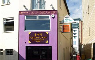 The purple painted outside of Fortune Court showing the entrance and adjacent alleyways.