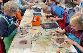 A group of adults and children taking part in a holiday workshop at The Box
