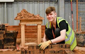 3. A young man works on a brick wall, arranging bricks skillfully to form a solid and even surface.
