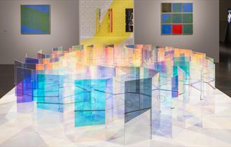 Photograph showing a colourful sculpture installation in a gallery