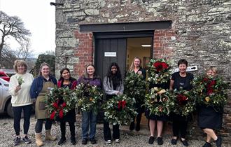 A few members from the Pentillie team holding Christmas wreaths they had made they had just made.