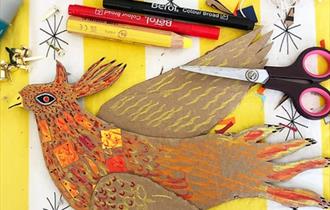 A cardboard phoenix on a crafting table