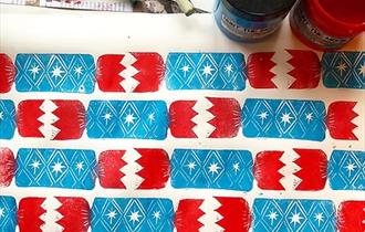 Block-printed blue and red Christmas crackers on wrapping paper