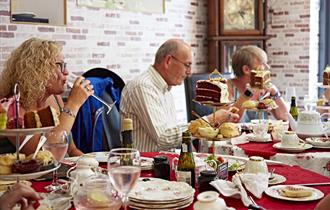 People sat at tables inside the tea rooms eating afternoon tea served from tiered cake stands.