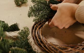 A person making a yule wreath