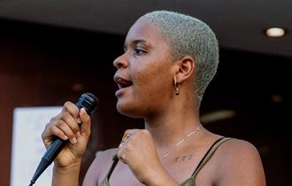 Woman with microphone. Photo Credit: Aiden Craver
