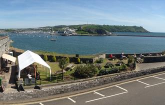 Dutton's Café and garden with views of Turnchapel, Mountbatten, Plymouth Sound and the Breakwater in the background.