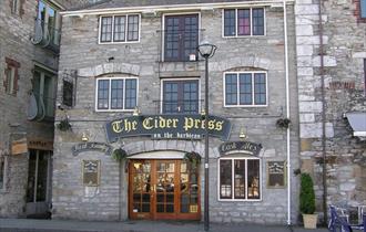 The stone outside of The Cider Press with wooden doors at the entrance.