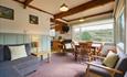 Corner sofa and dining table and chairs in a windowed room with beamed ceiling