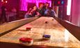 People playing with shuffleboard