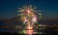 Fireworks launching from the pier at night