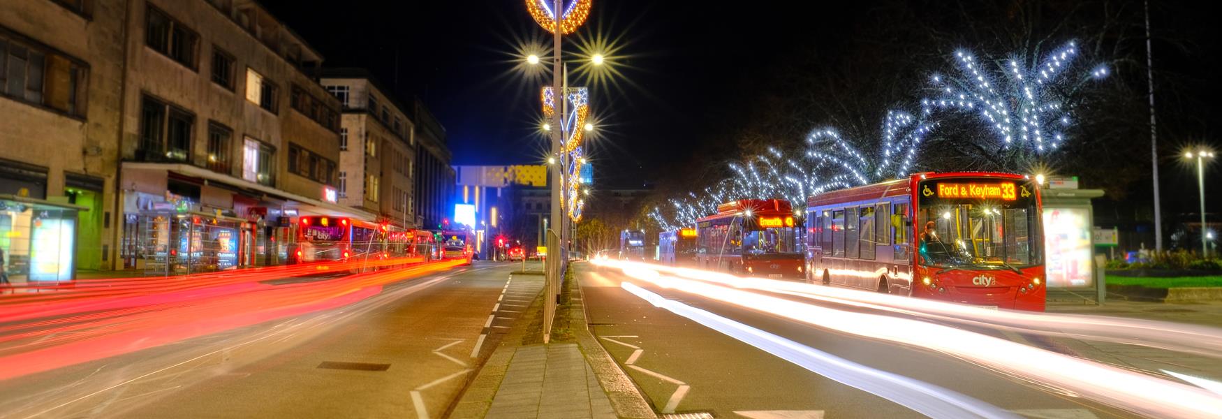 Christmas lights on street with buses