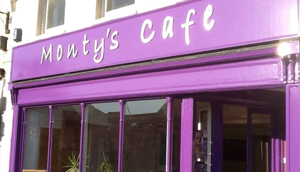 The purple shop front of Monty's showing large windows and the café name.