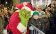 The Grinch with a child at the Barbican Christmas lights switch-on event in Plymouth