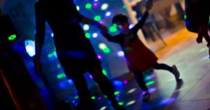 A family on a dance floor at a disco
