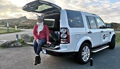 Tour land rover with happy customer sat on edge of boot