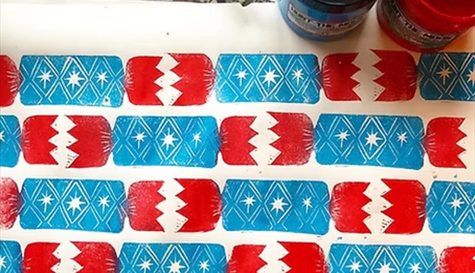 Block-printed blue and red Christmas crackers on wrapping paper Block-printed blue and red Christmas crackers on wrapping paper