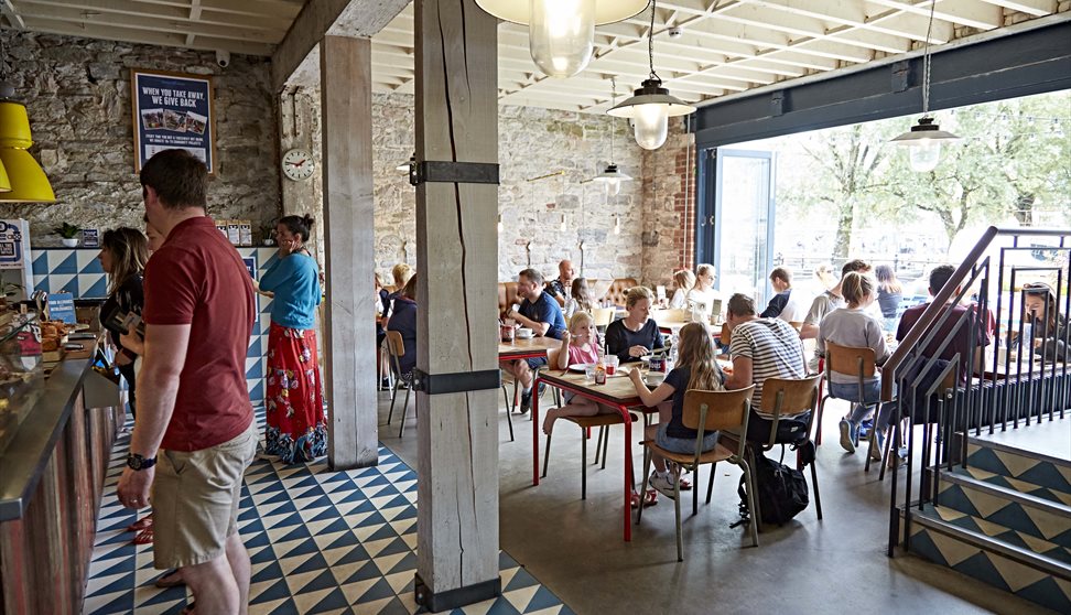 The inside of Boston Tea Party showing customers  at the counter ordering food and drinks and other customers seated at tables.