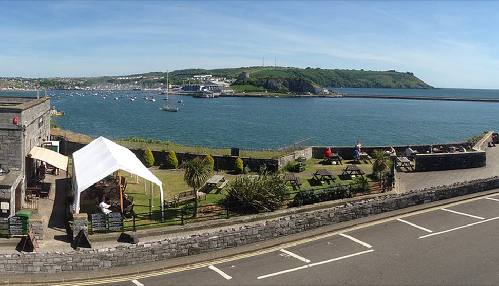 Dutton's Café and garden with views of Turnchapel, Mountbatten, Plymouth Sound and the Breakwater in the background.