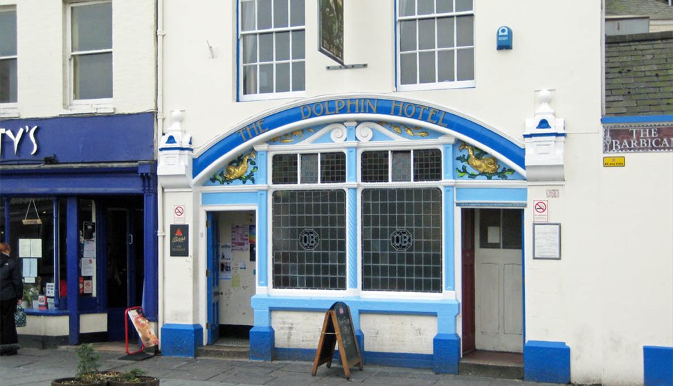 Exterior of The Dolphin with blue painted exterior, stain glass windows and painted dolphins.