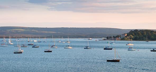 immense views of brownsea island with boats moored in Poole harbour