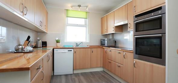 Large kitchen with soft wood and modern appliances