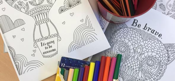 image shows felt tip pens, colouring sheets and crayons