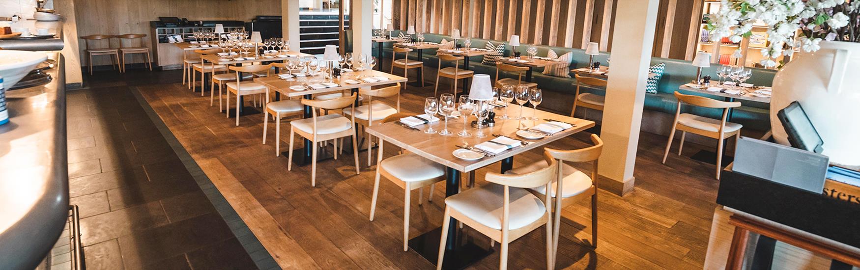 Tables and chairs set up nicely with slight view of the kitchen