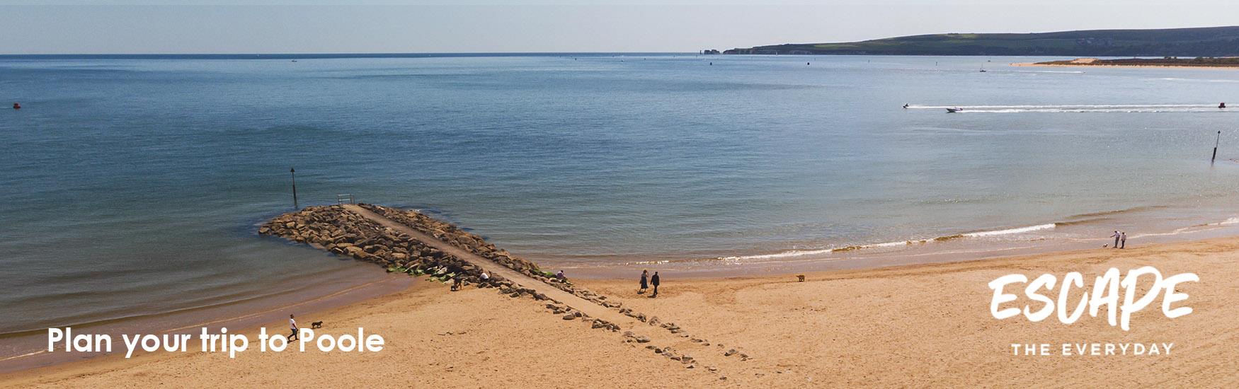 Visitors enjoying an autumn walk along one of Pooles beautiful beaches with a logo overlay that reads Escape the Everyday