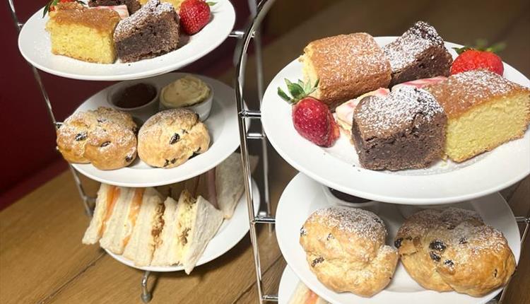 Afternoon tea with plates of cakes and sandwiches
