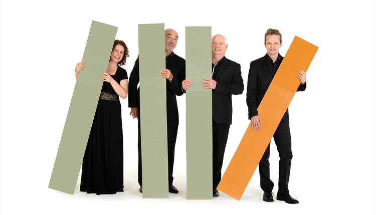 Four musicians are stood behind coloured rectangles graphics.