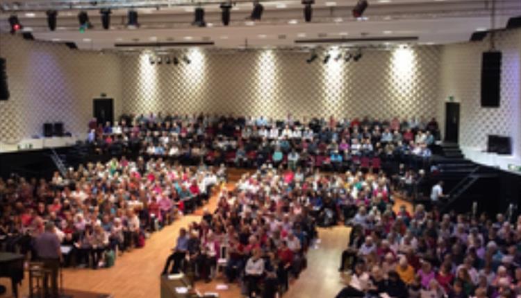 image of a large concert hall filled with people singing