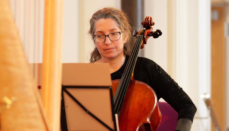 Kate Keats (BSO Cellist) is playing the cello at a cake concert.