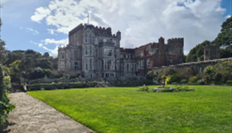 View of Brownsea castle with the lawn at the front and blue shy above.