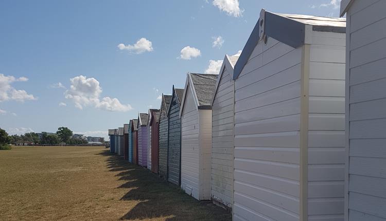 Colourful array of beach huts lined up along Hamworthy park in Poole