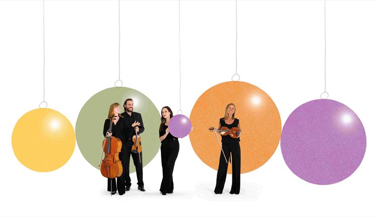 Image of 4 BSO musicians standing in front of giant Christmas baubles