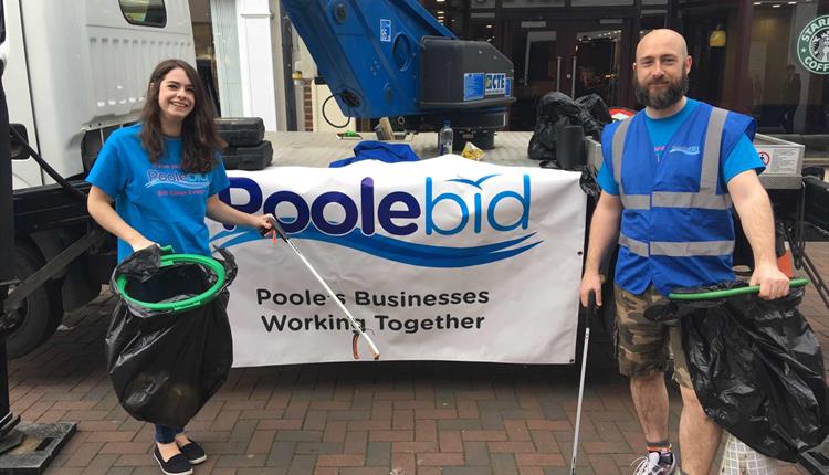 Two volunteers of the clean up stand proudly in the high street