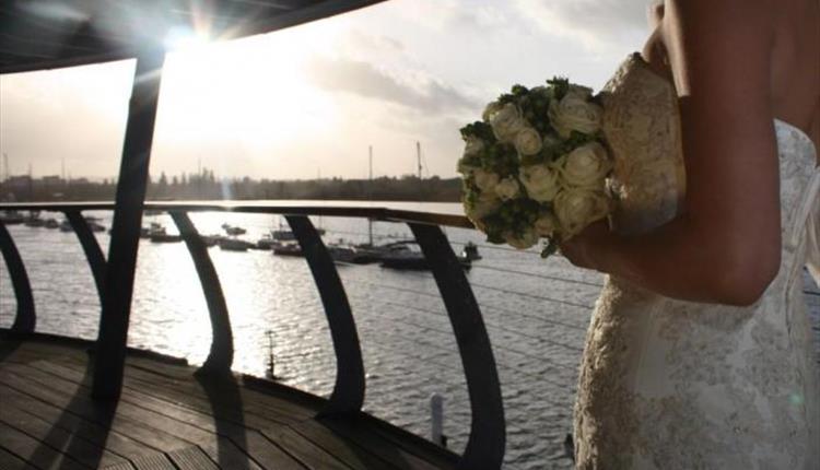 Image of bride on balcony of RNLI College, Poole, Dorset. Wedding Show.
