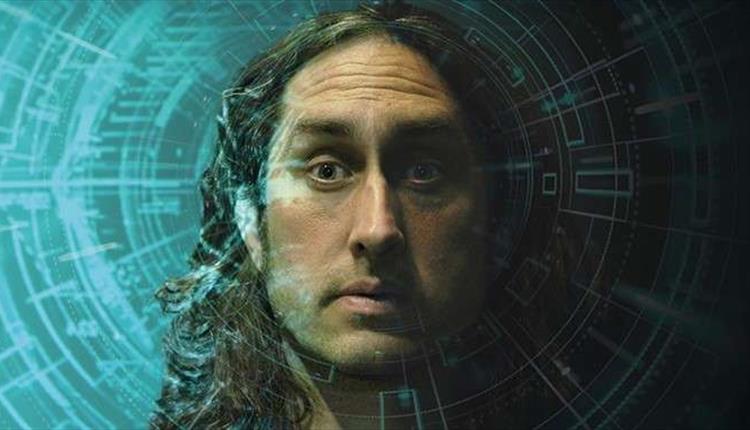 A man with long black hair looking directly into a camera.