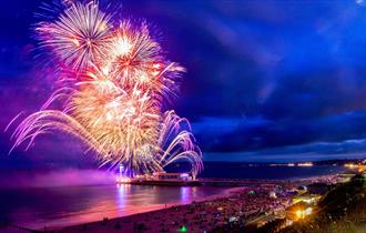 Beautiful colourful image of fireworks over Bournemouth Pier and the sea