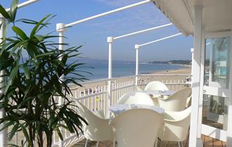 White table and chairs on the balcony overlooking the stunning views of Bournemouth beach and coastline