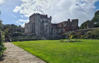 View of Brownsea castle with the lawn at the front and blue shy above.