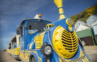 Blue and yellow land training driving along Bournemouth seafront