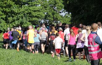 Parkrun participants in the grass and trees at Upton House.