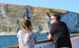 Two customers looking out from the boat at the mesmerizing Jurassic coast