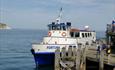 White and blue boat in front of docked at Swanage Pier