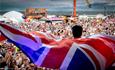 an act on stage with the union jack flag around them