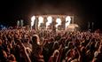crowds at the stage with fire being blown