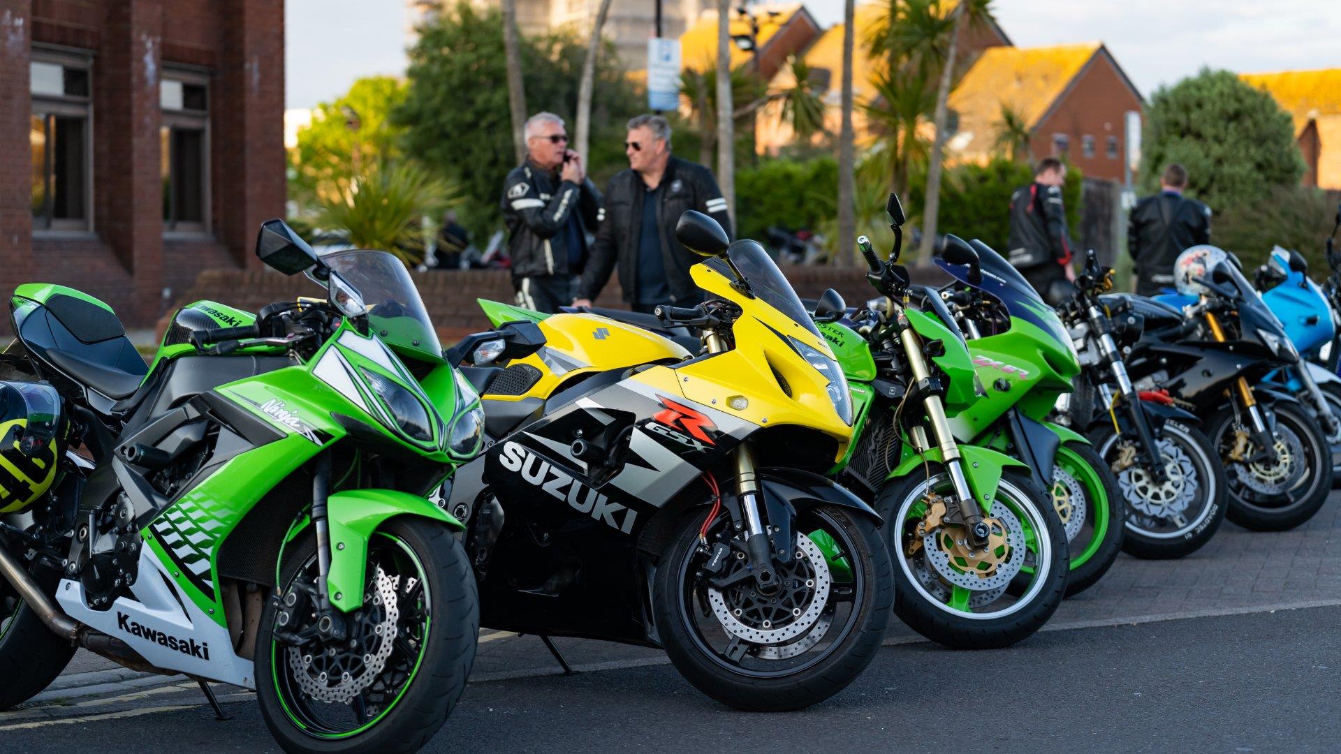 Row of different coloured motorbikes lined up at Poole Quay