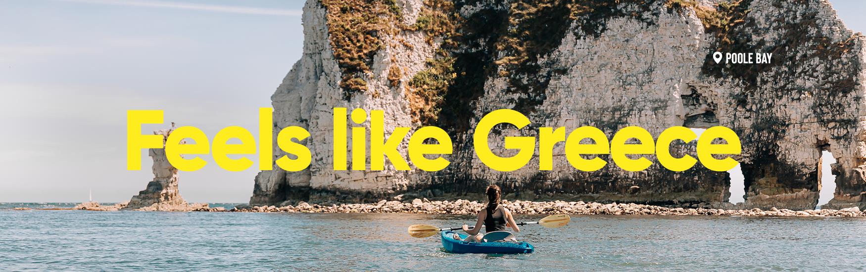 Kayaking soaking up the sun and views of white rocks near Poole with text that reads feels like Greece